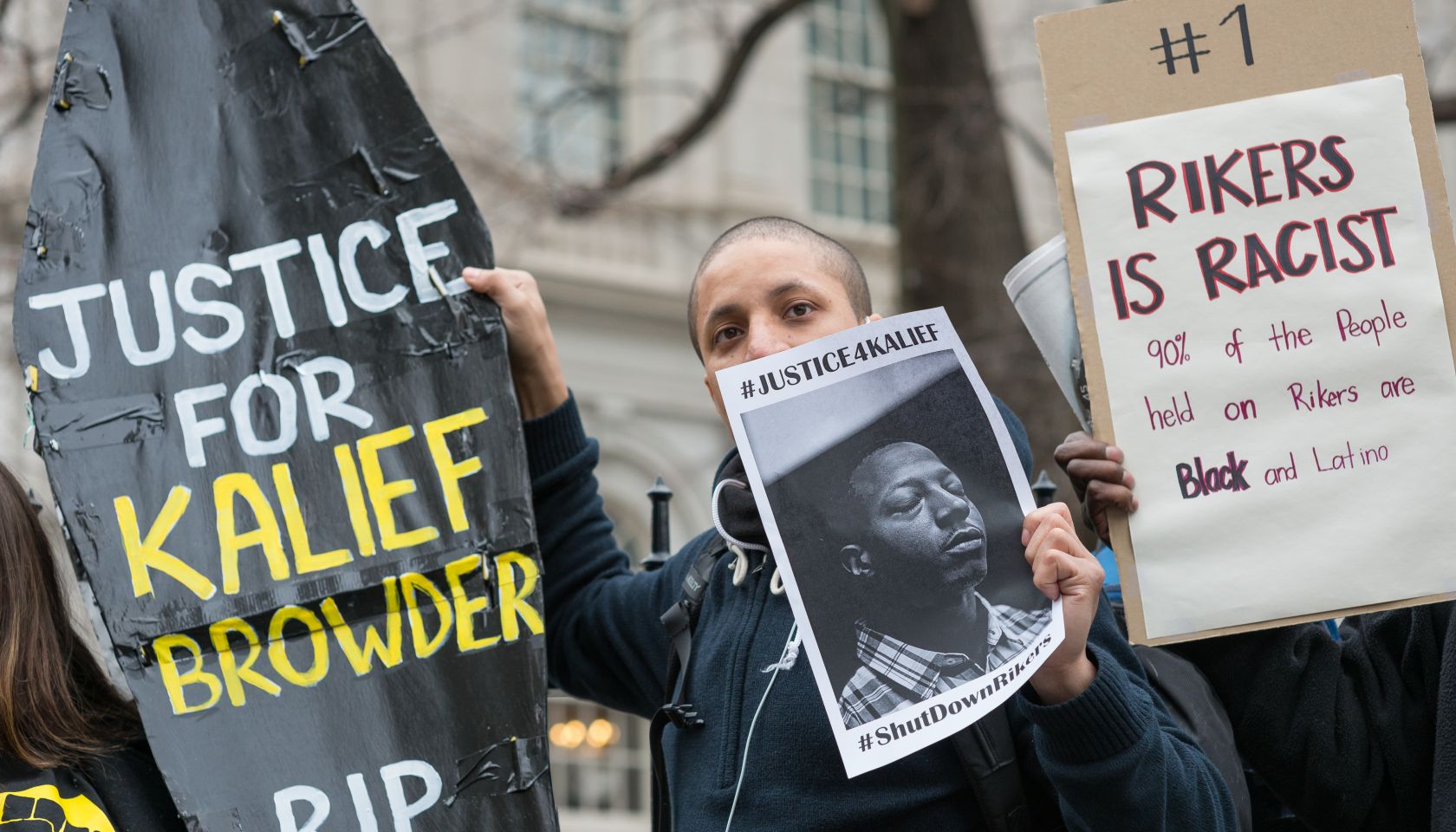 Demonstrators hold aloft a symbolic coffin bearing Kalief...