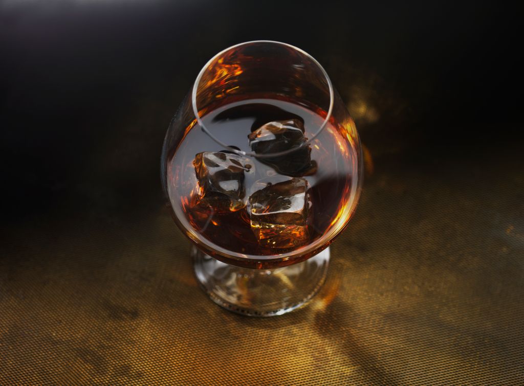 glass of cognac on dark gold background