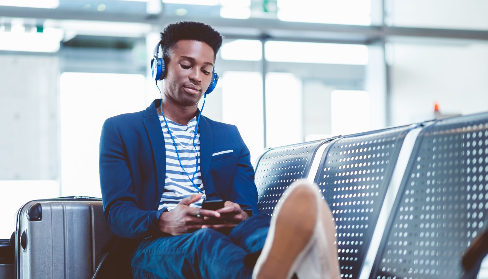 Young african man waiting for flight at airport lounge