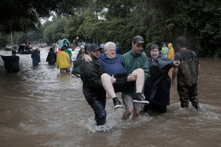 Police and volunteers rescue residents flooded by the San Jacinto river in Kingwood, Tex.