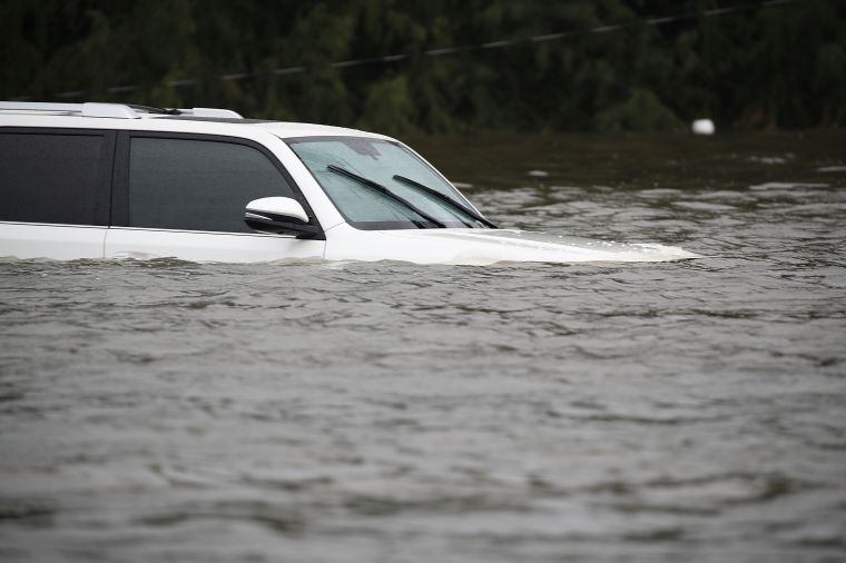 An SUV is submerged in flood water.