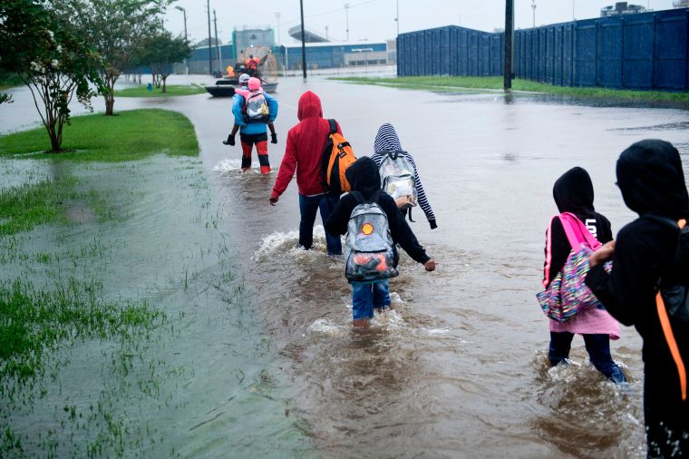Young kids escape a flooded neighborhood.