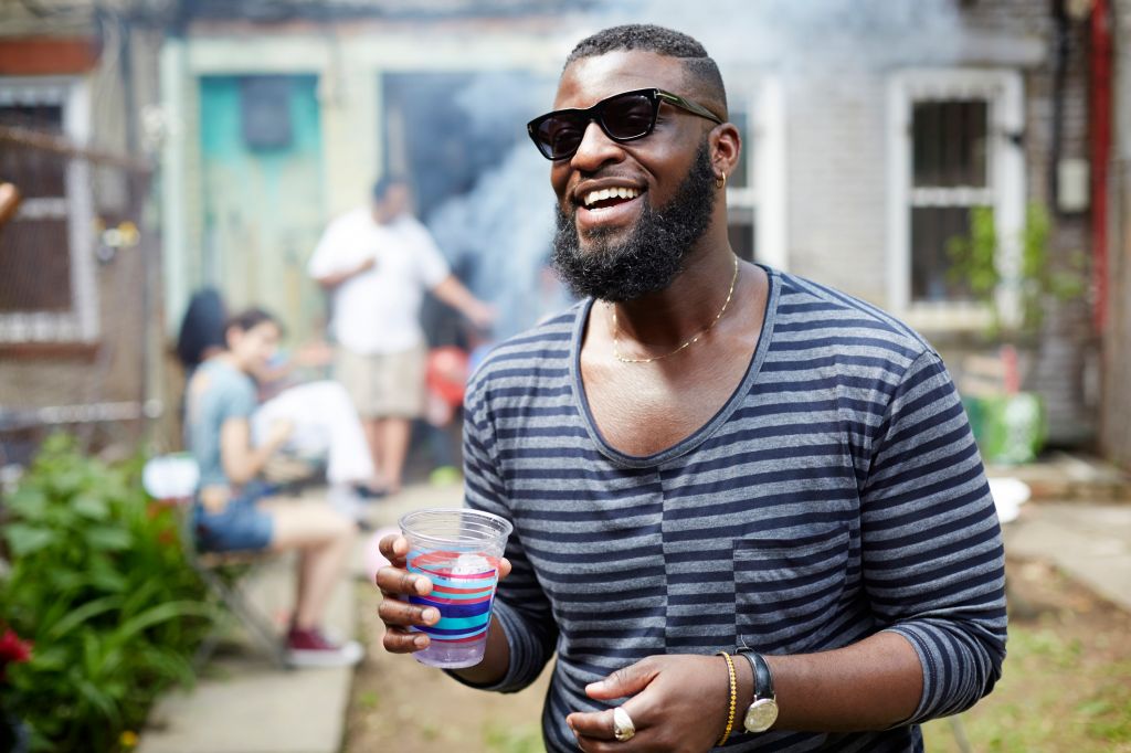 African American man drinking at backyard barbecue