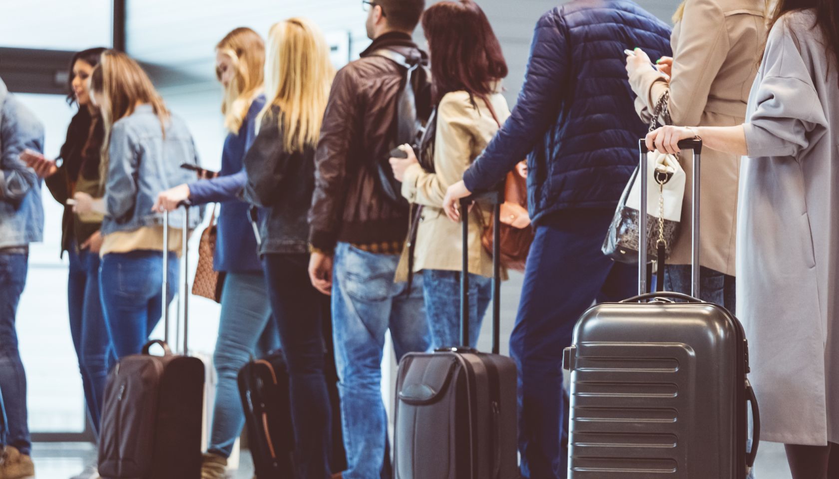 Group of people standing in queue at boarding gate