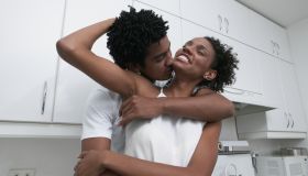 African couple hugging in kitchen