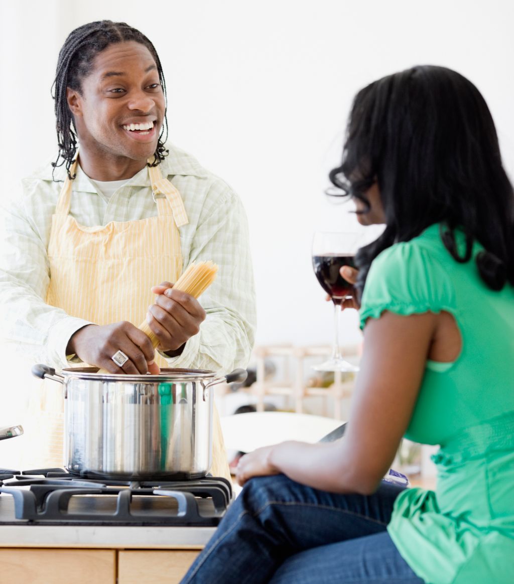 African couple cooking in kitchen