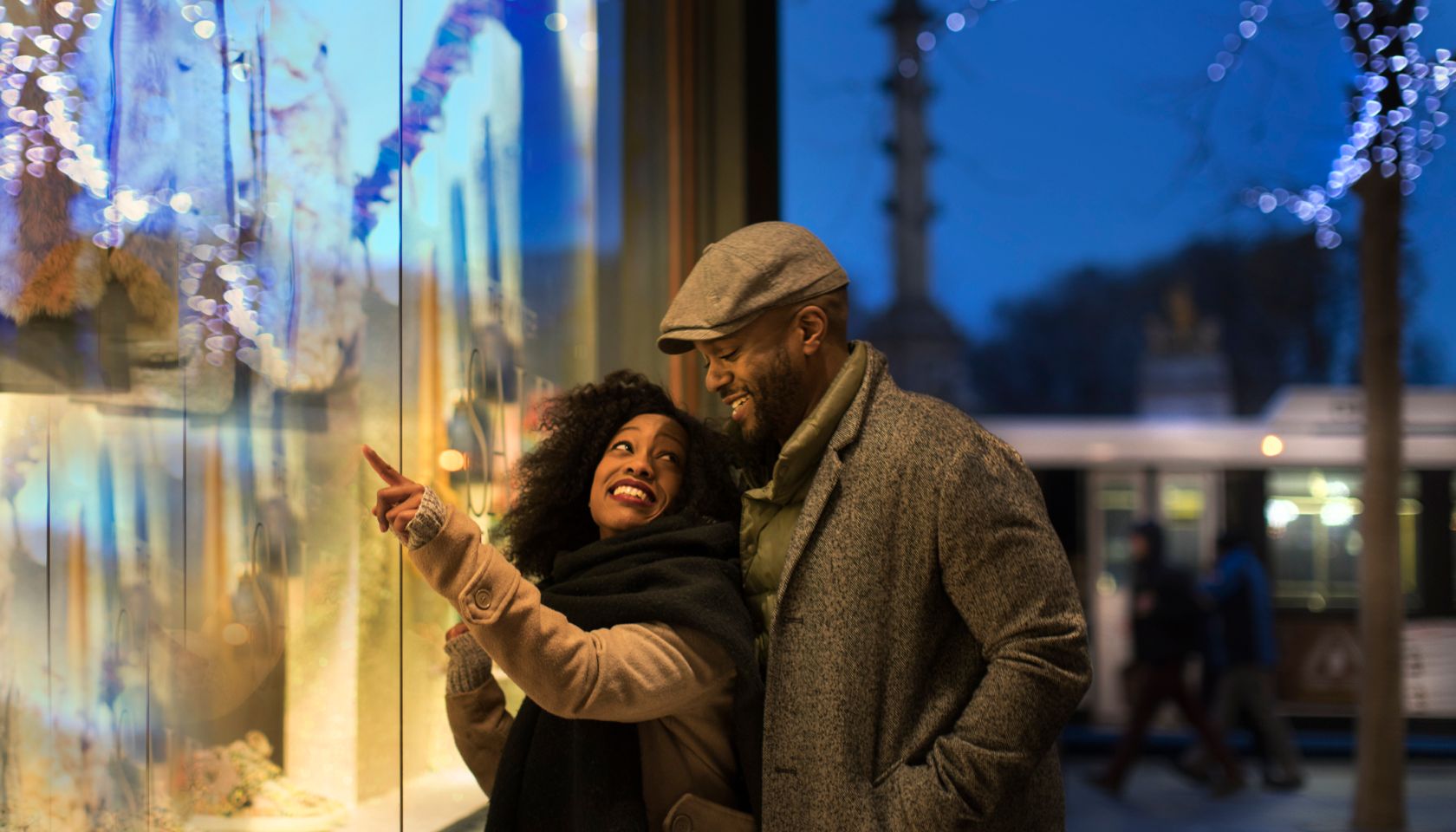 Couple window shopping in city at night, New York, USA