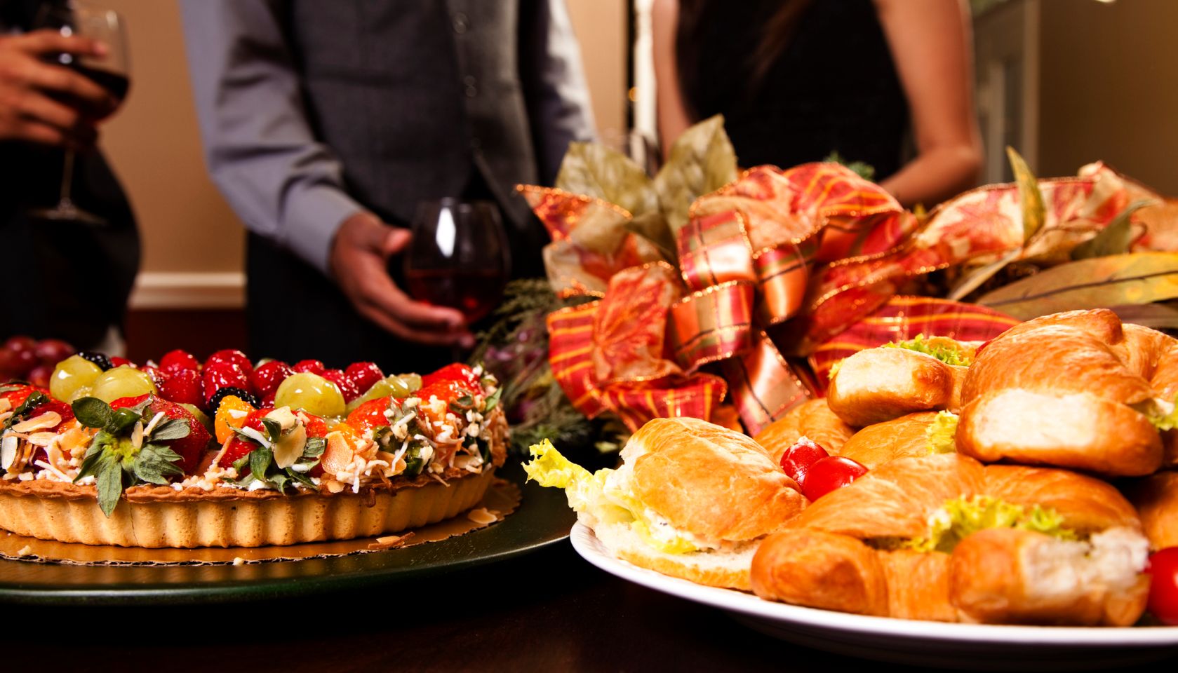 Friends sharing wine, food, appetizers. Holiday dining.