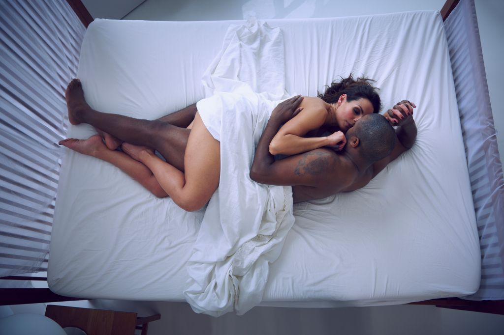 Woman and man cuddling in bed