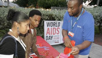 Man showing a couple sexually transmitted disease brochures for World AIDs Day