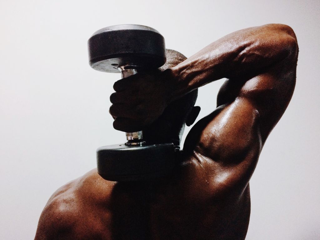 Shirtless Man Holding Dumbbell Against White Background