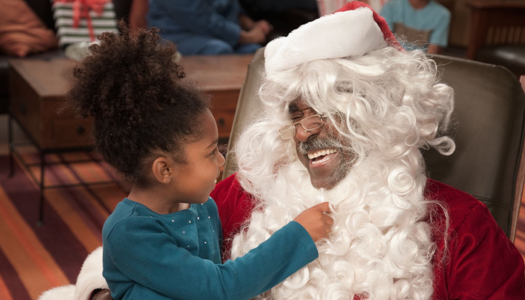 Girl pulling on Santa's beard