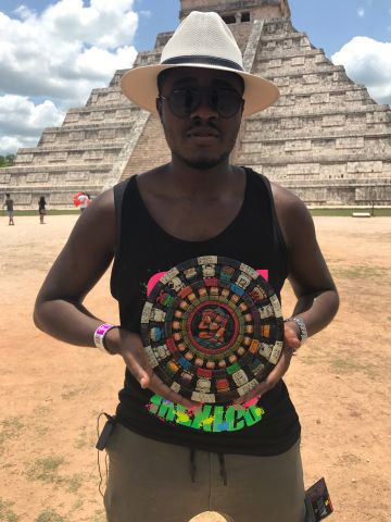 Young Man Holding Mayan Artifact Against El Castillon Pyramid