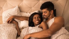 Young loving black couple lying in the bed and communicating.