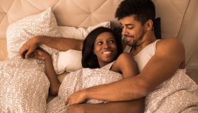 Young loving black couple lying in the bed and communicating.
