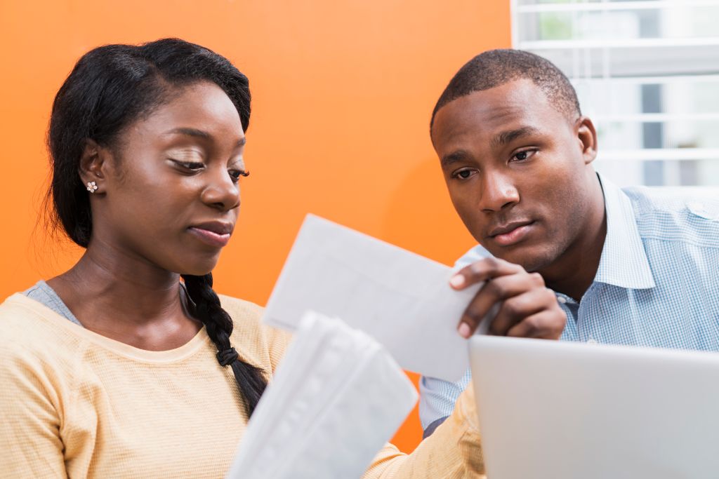Young black couple paying bills at home