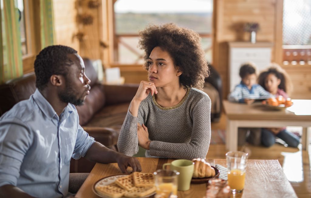 African American couple talking during breakfast time at home.