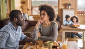 African American couple talking during breakfast time at home.