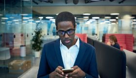 Modern African-American Businessman Using Phone in Office