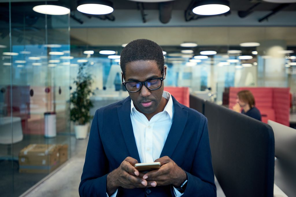 Modern African-American Businessman Using Phone in Office