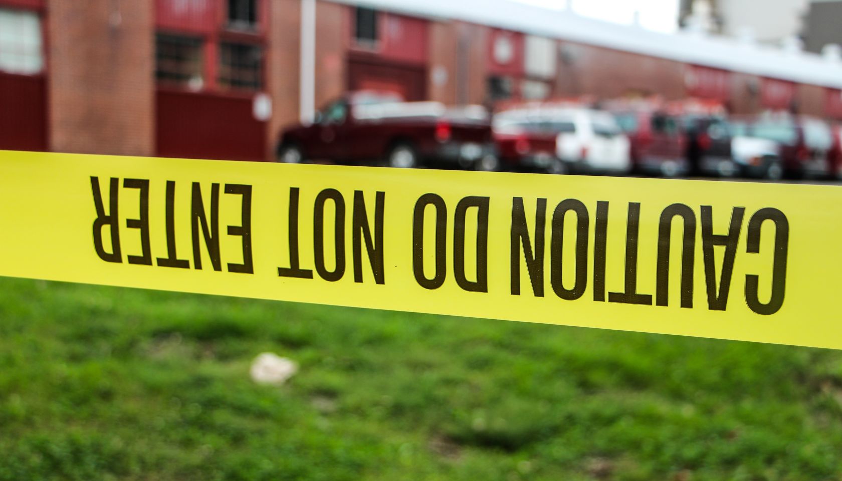Caution Tape Over Grassy Field