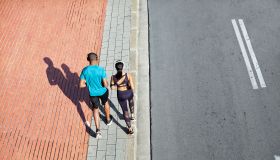 High angle view of couple jogging on sidewalk