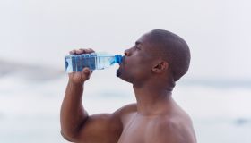 Side profile of a young man drinking water from a bottle