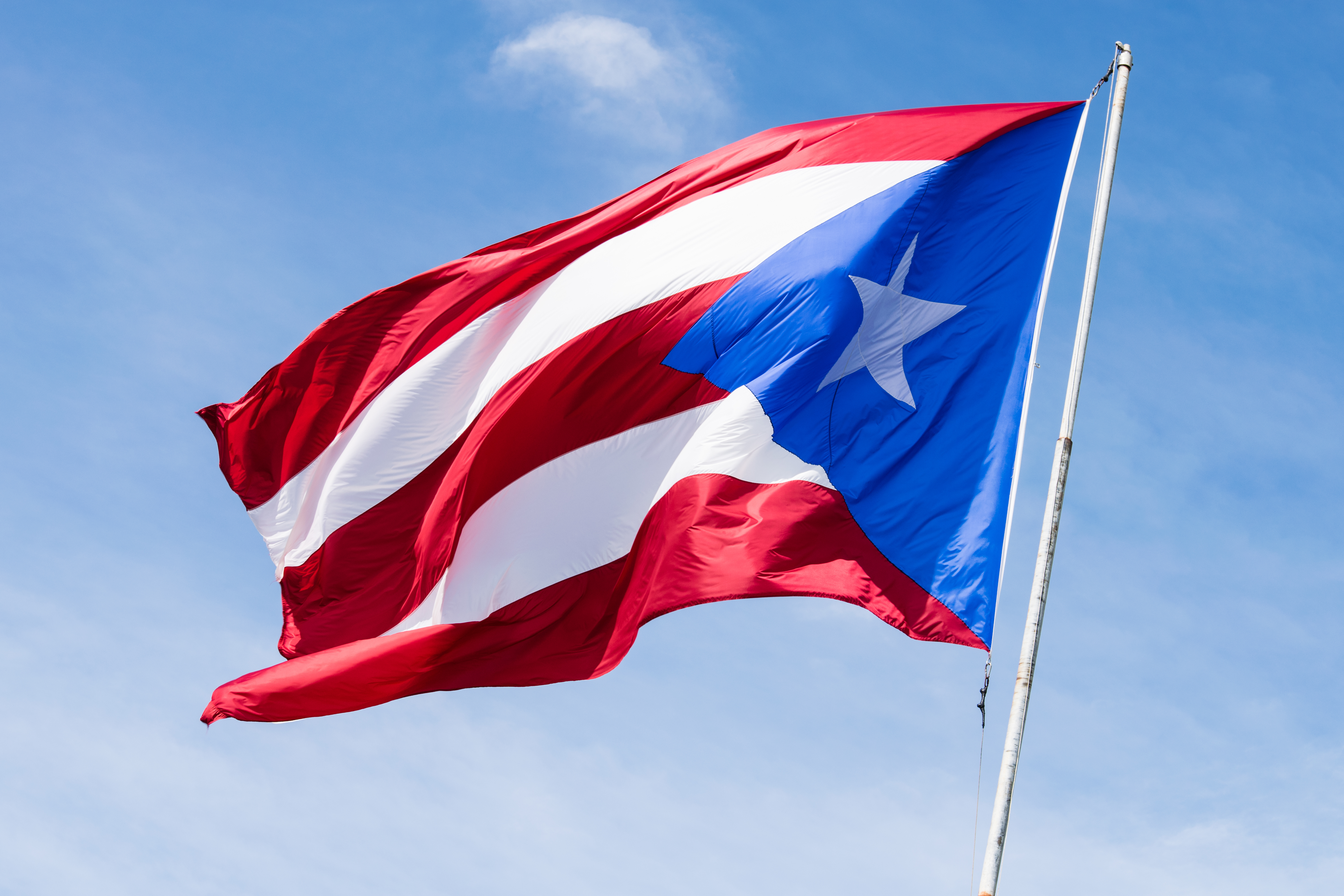 Low Angle View Of Flag Waving Against Sky