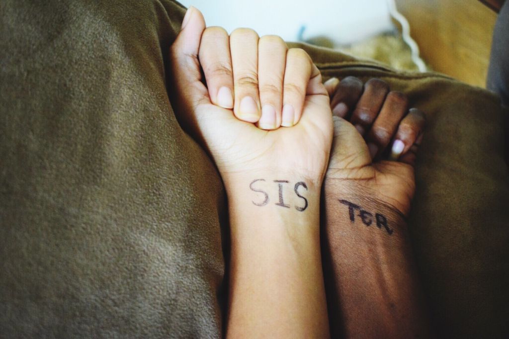 Cropped Image Of Hands With Text On Bed