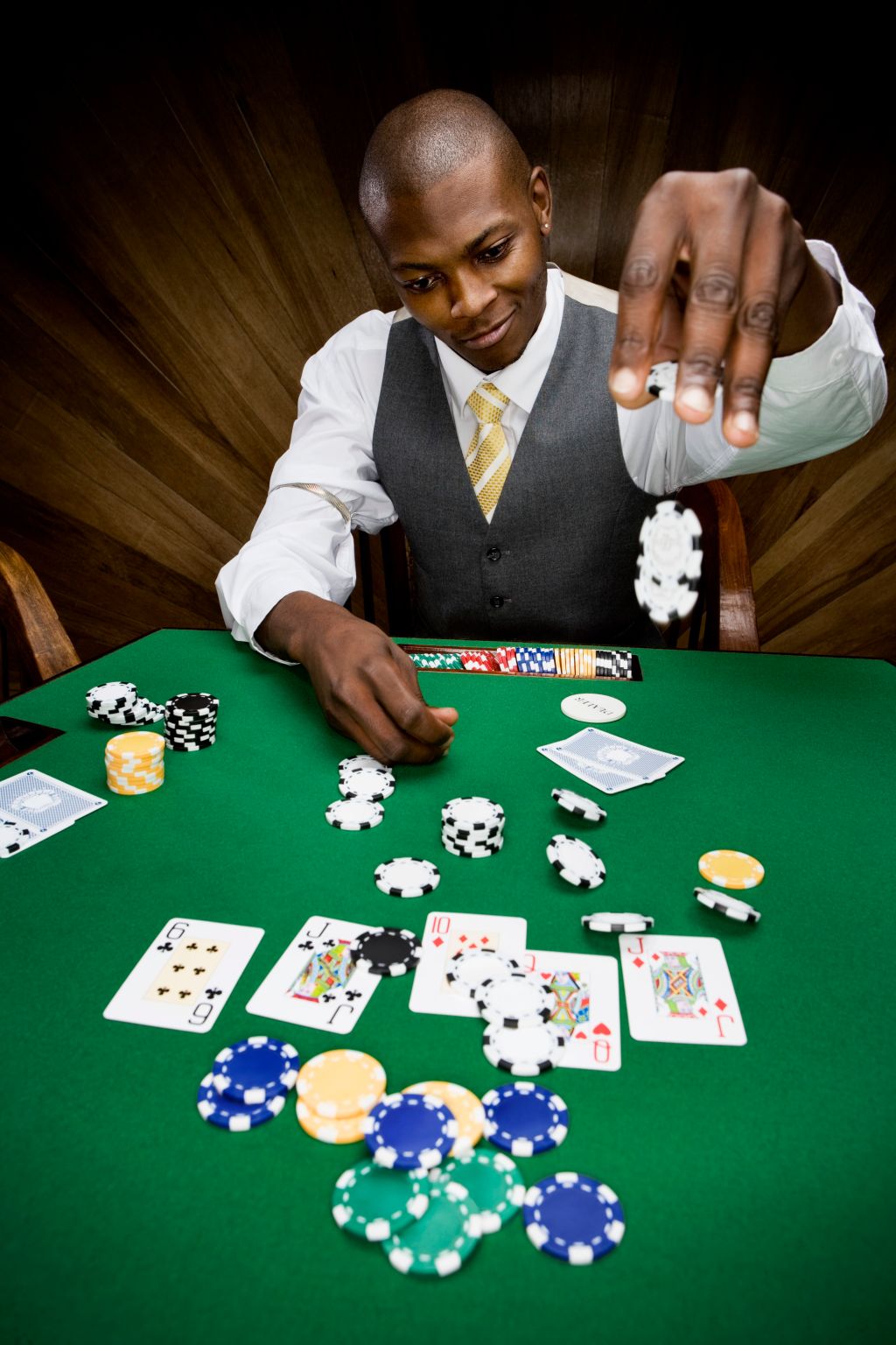 Man dropping poker chips on table