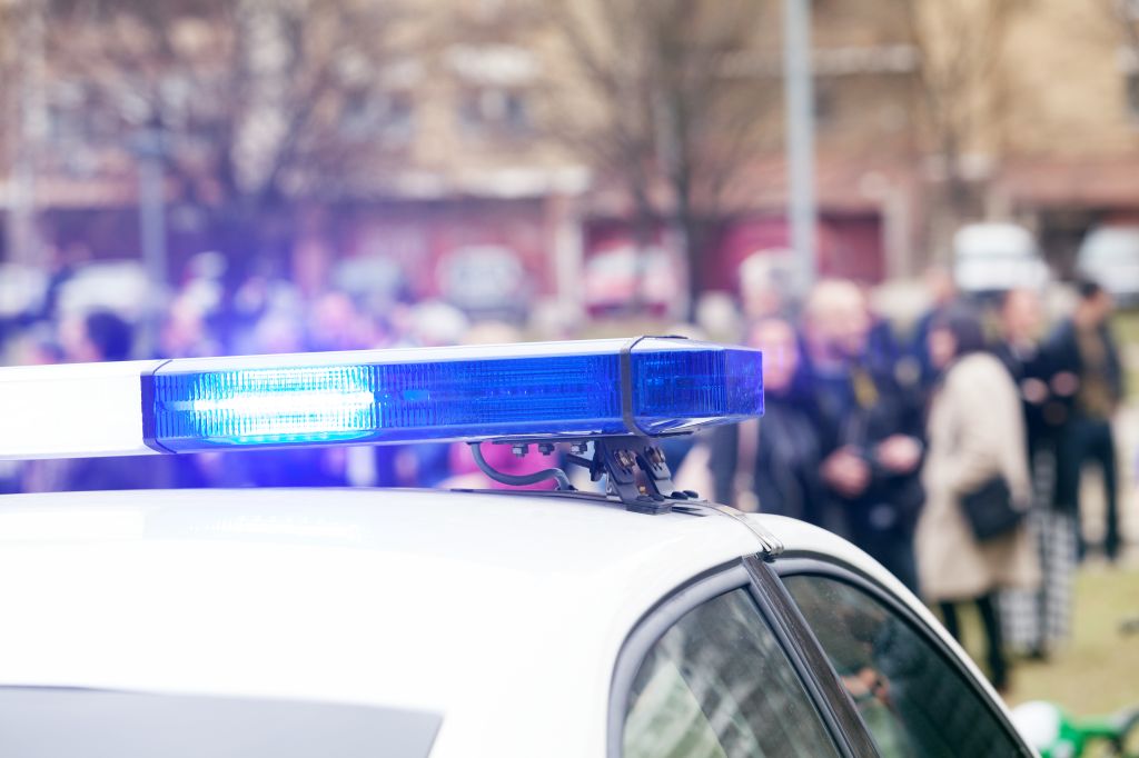 Close-Up Of Police Car With People In Background