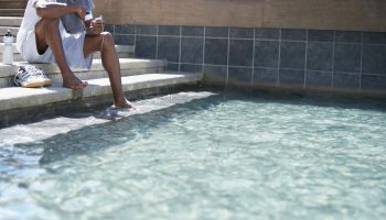 Man relaxing with feet in pool