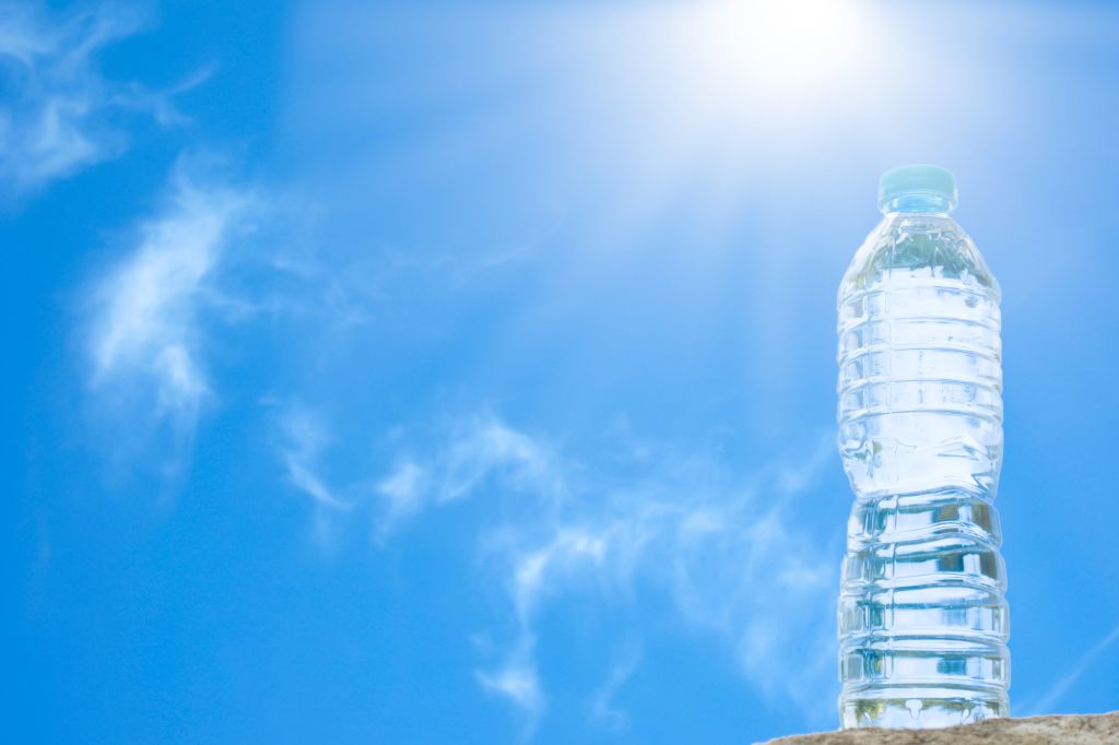 Low Angle View Of Water Bottle On Wall Against Blue Sky