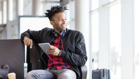 Young african using digital tablet in airport lounge
