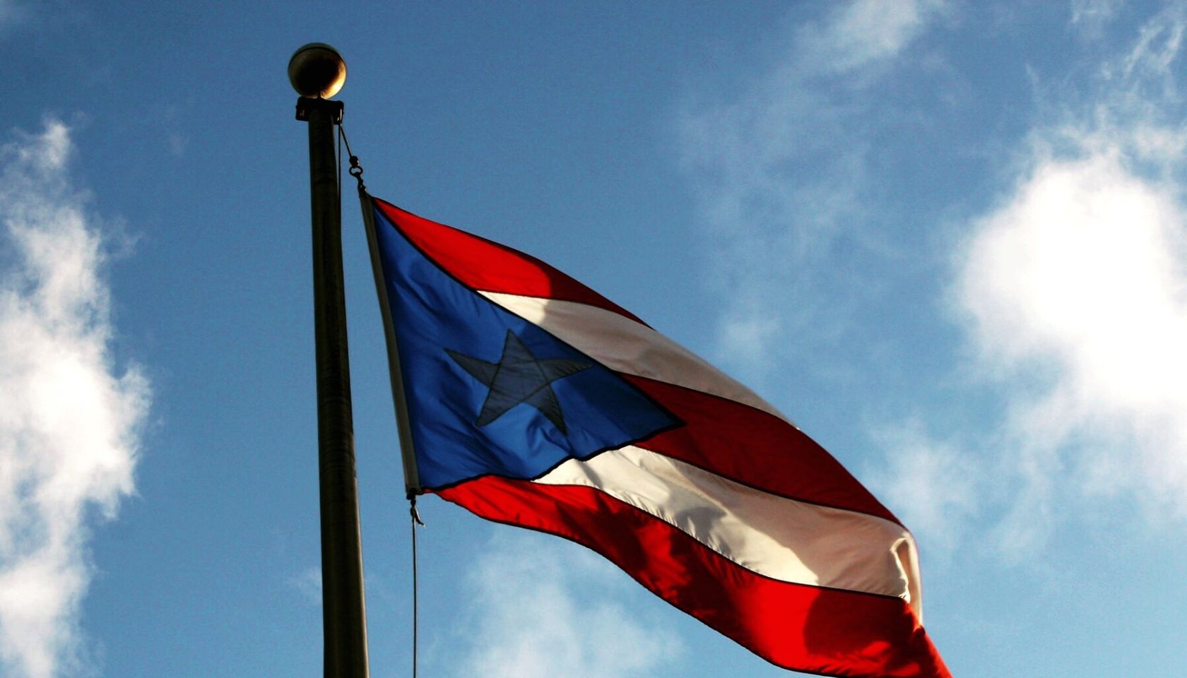 Low Angle View Of Flag Against Blue Sky