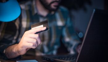 Close-up of a man using credit card to shop from home