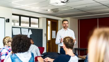 Male professor teaching students in classroom