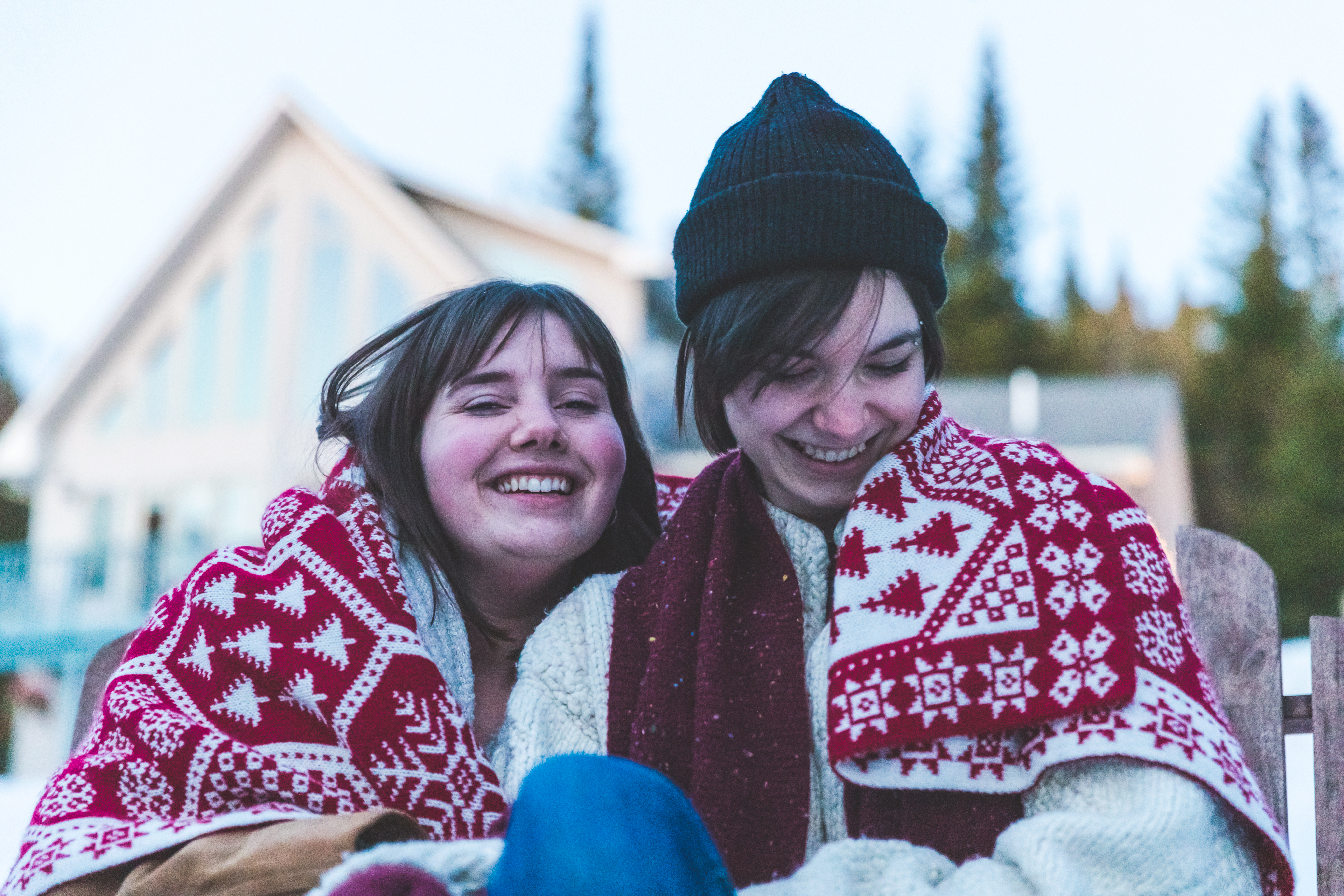 Lesbian Couple Wrapped in the Warm Blanket sitting outside their Holiday Villa