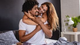 Young couple at home in bed smiling