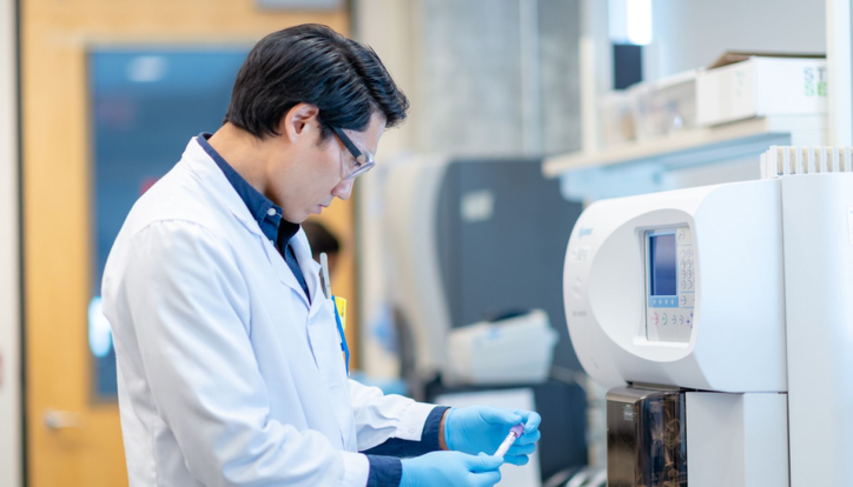 Asian Scientist Checking a Vial Before Processing it in the Equipment stock photo