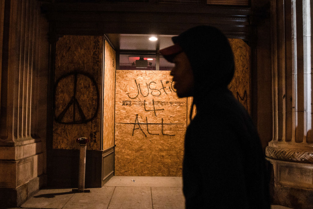 A protester walks past justice 4 all graffiti outside the...