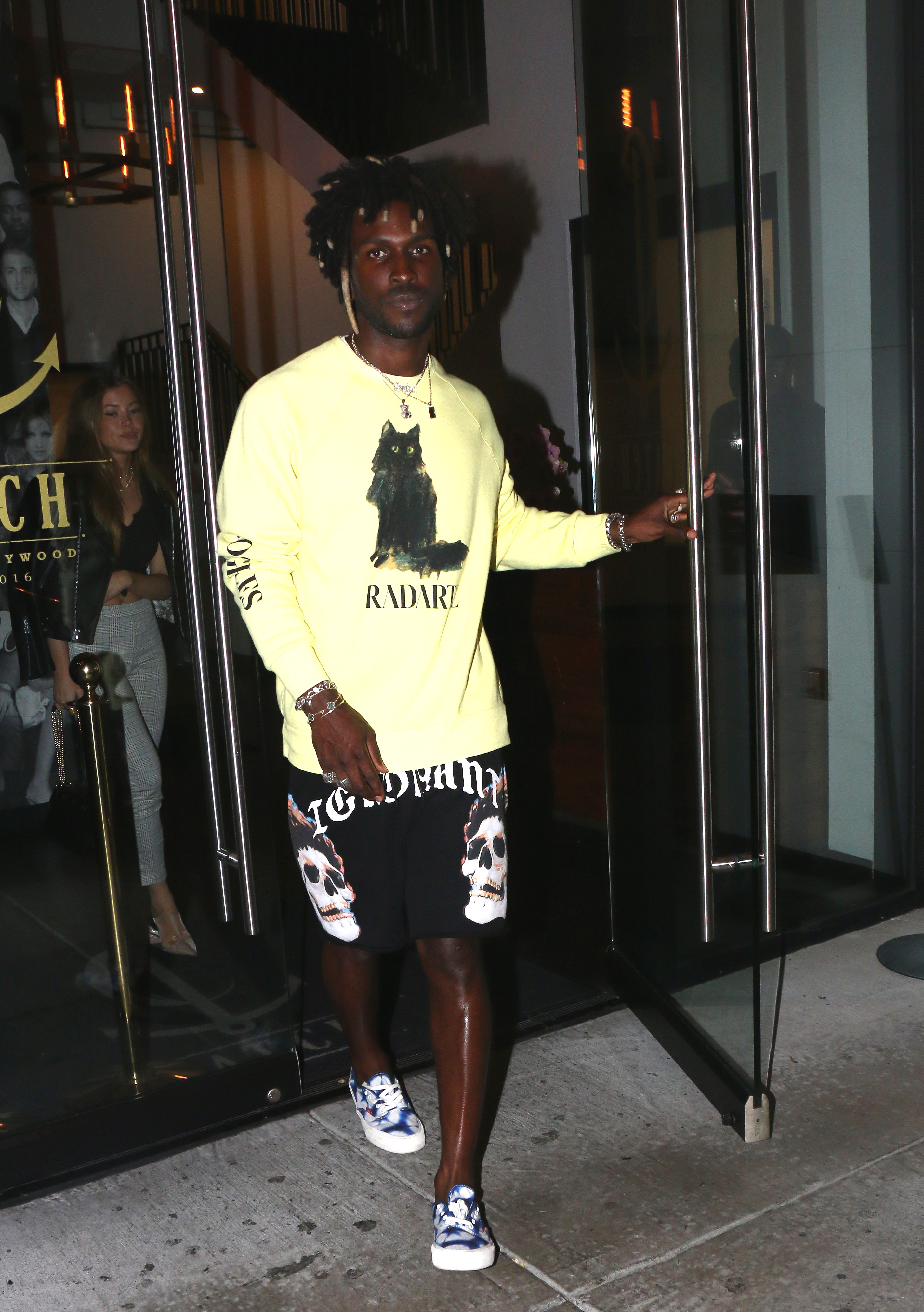 Saint Jhn, wearing a pale yellow Radarte cat sweatshirt, leaves Catch in West Hollywood with a female friend