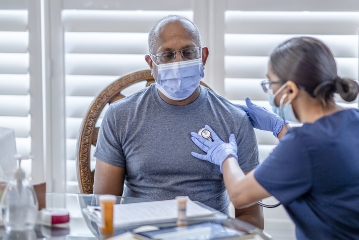 Female medical professional on a house call in patients home