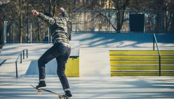 Skateboarder sliding on a rail in the skatepark