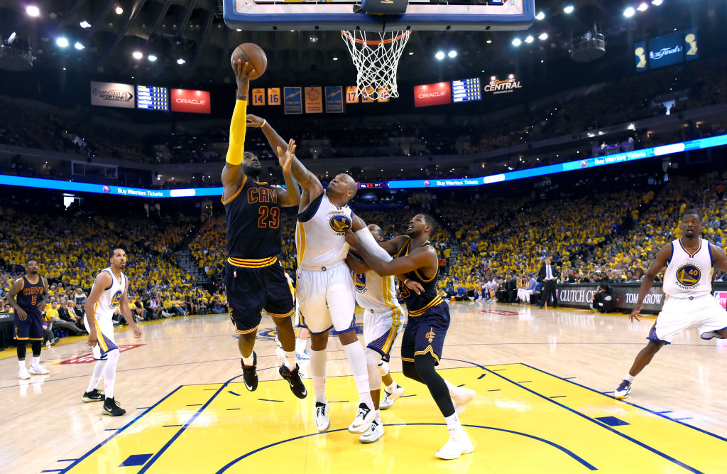 From left, Cleveland Cavaliers' LeBron James (23) tries to make a basket as Golden State Warriors' Marreese Speights (5) blocks and Warriors' Andre Iguodala (9) gets blocked by Cleveland Cavaliers' Tristan Thompson (13) in the second quarter of Game 2 of