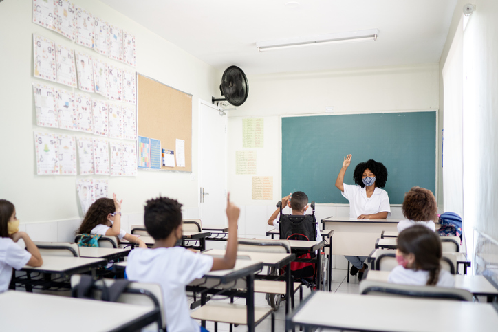 Teacher teaching in classroom respecting social distancing between students