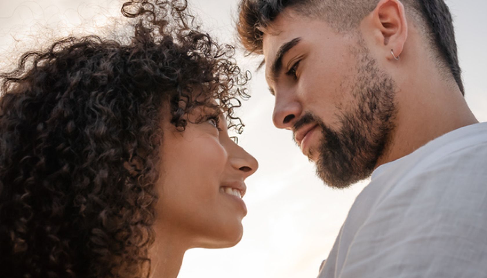 Close-Up Of Couple Embracing While Standing Against Sky