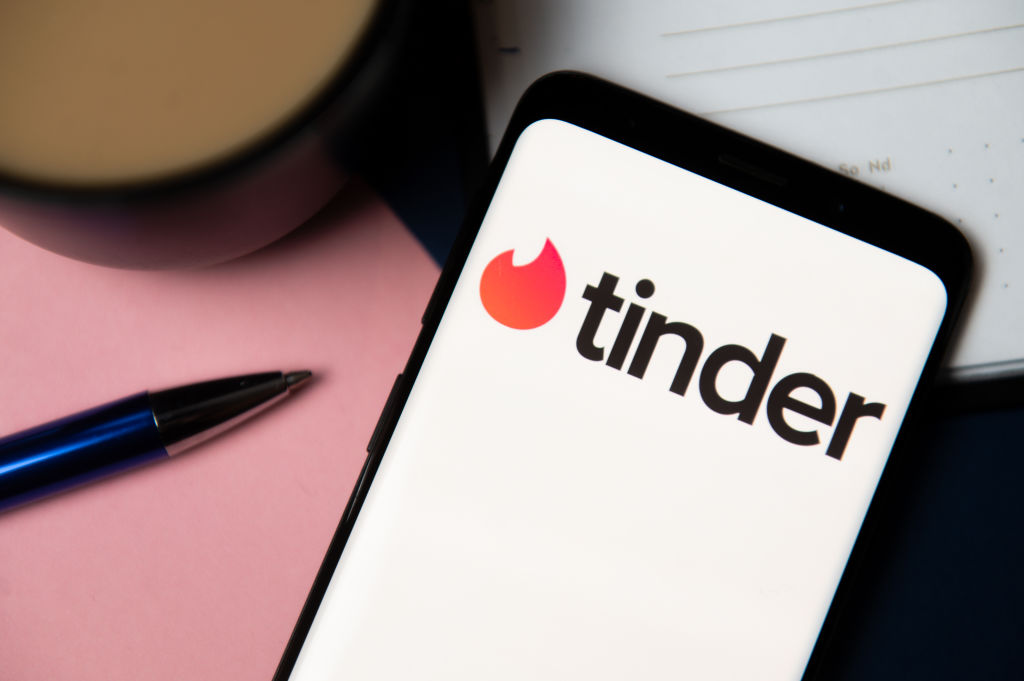 In this photo illustration a Tinder logo displayed on a...
