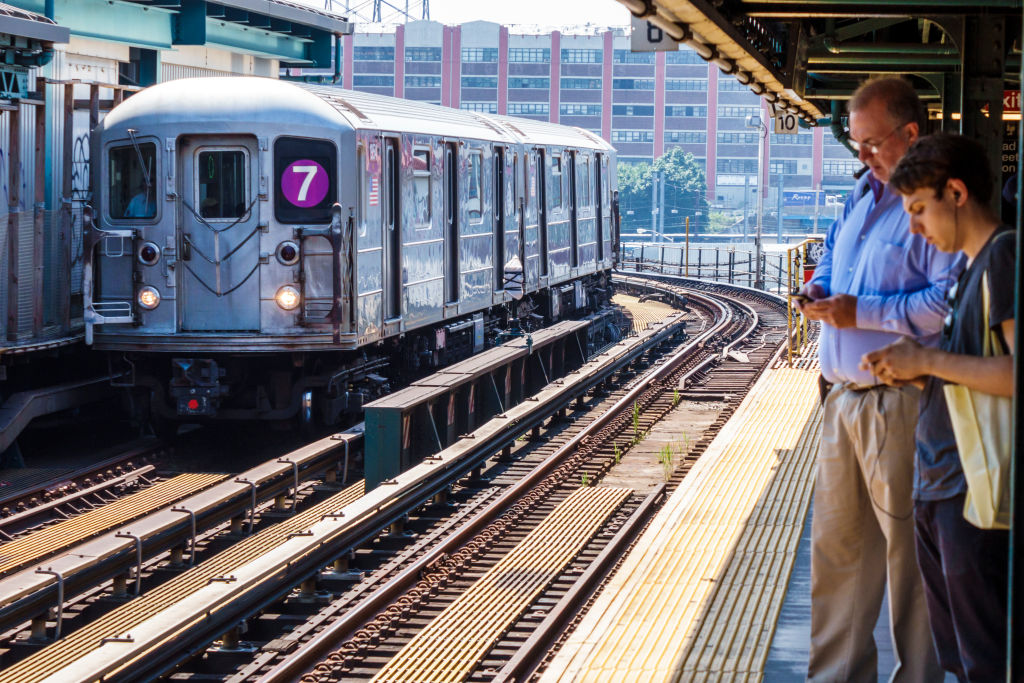 New York, Queens, Court Square subway platform, 7 Line train with commuters