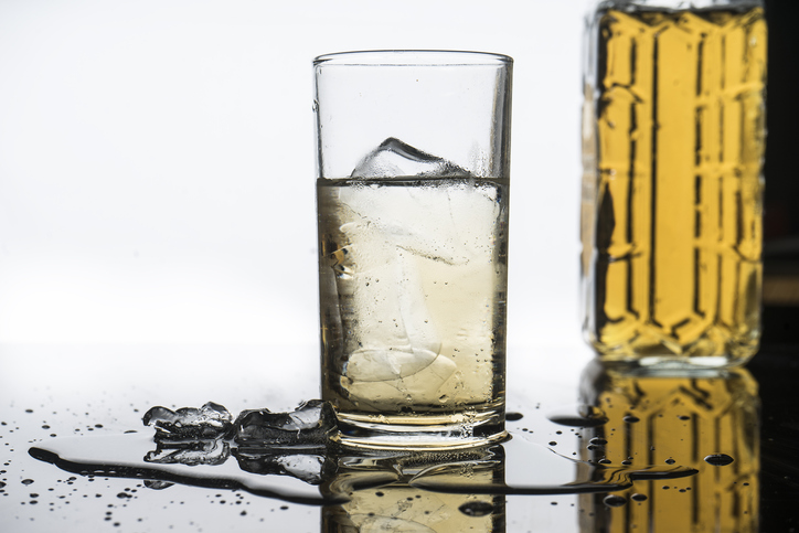 selective focus drink alcohol and water glass with whisky and Sparking water and ice cube